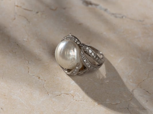 A mid-century platinum cocktail Ring using a Baroque pearl centre 